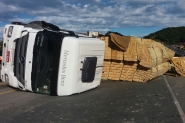Caminhão carregado de madeira tomba sobre veículo na BR-470, em Gaspar