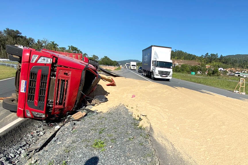 Carreta carregada de casquinha de soja tomba e motorista fica ferido em Ilhota